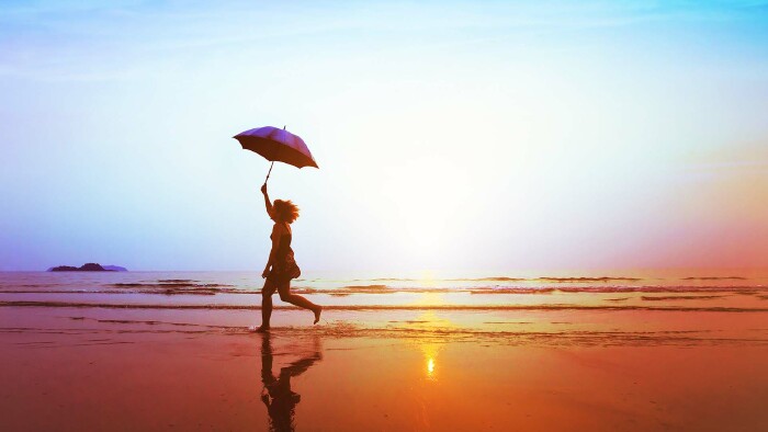 © Song_about_summer, stock.adobe.com Silhouette eines glücklichen Mädchens mit Sonnenschirmsprung am Strand